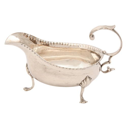 457 - A George III silver sauceboat, with flying scroll handle, on three hoof feet, 14cm l, underside engr... 