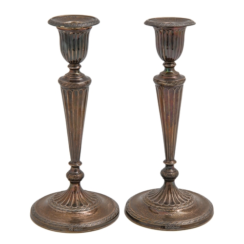 534 - A pair of George V silver candlesticks, in neo classical style, nozzles, 23cm h, by Elkington & ... 