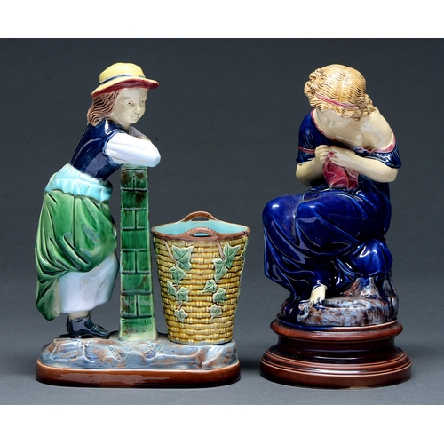 612 - Two majolica figures of girls, late 19th c, one kneeling beside a basket, 25cm h, unmarked... 