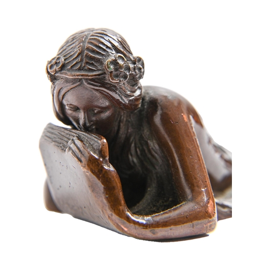 824 - An Art Nouveau bronze figural letter knife, c1900, the handle in the form of a reclining nymph, rich... 