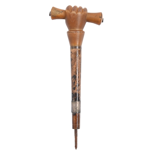 825 - A cane or parasol handle, 19th c,  the pommel carved as a baton in a clenched fist, 20cm h... 