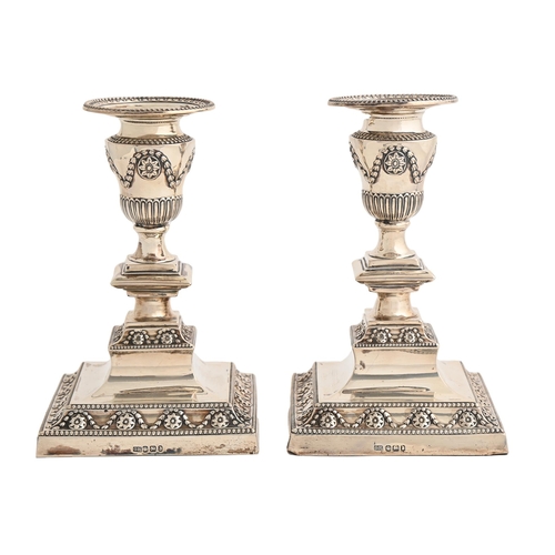 107 - A pair of Victorian silver dwarf candlesticks,  in neo classical style, on beaded square foot, nozzl... 