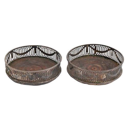 116 - A pair of George III neo classical pierced and engraved silver wine coasters, with beaded rims, cres... 