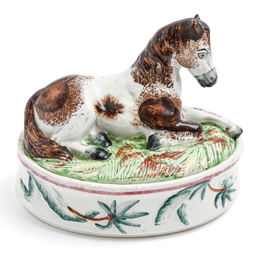 195 - A Staffordshire earthenware egg box, c1860, the cover in the form of a recumbent pony, 18cm hThe col... 