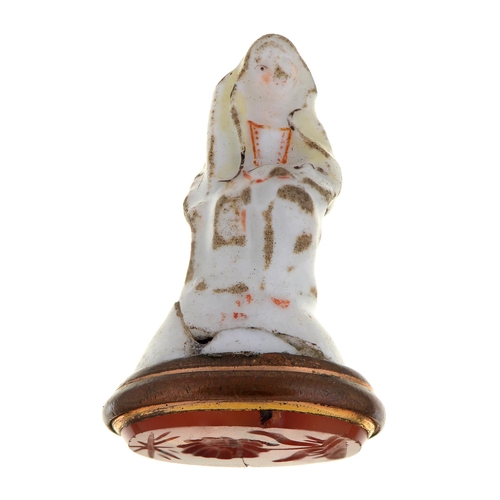 203 - A St James porcelain fob seal in the form of a nun, c1758-60, with cornelian flower intaglio with co... 