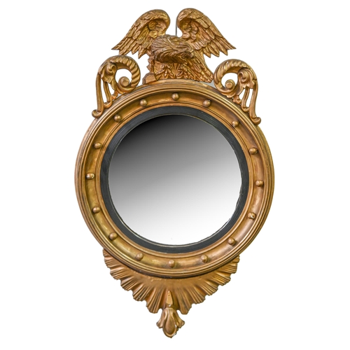 357 - A Victorian giltwood convex mirror, the circular cavetto frame crested by an eagle on rock, shell ap... 