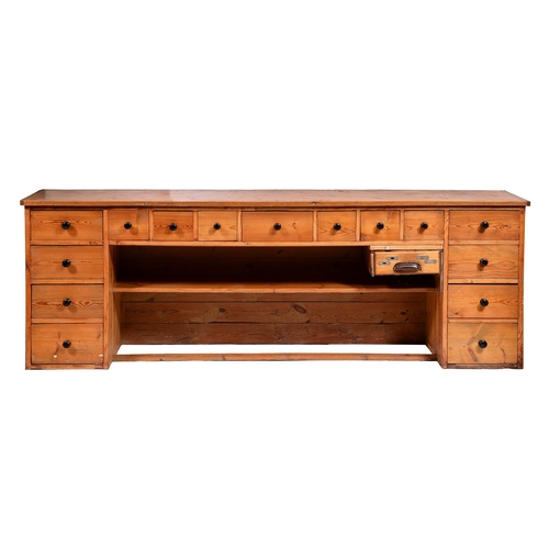 412 - A pine counter, one side fitted with fifteen drawers and a till, 85cm h; 56 x 251cmThe collection of... 