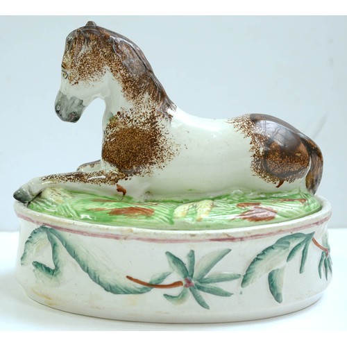 195 - A Staffordshire earthenware egg box, c1860, the cover in the form of a recumbent pony, 18cm hThe col... 