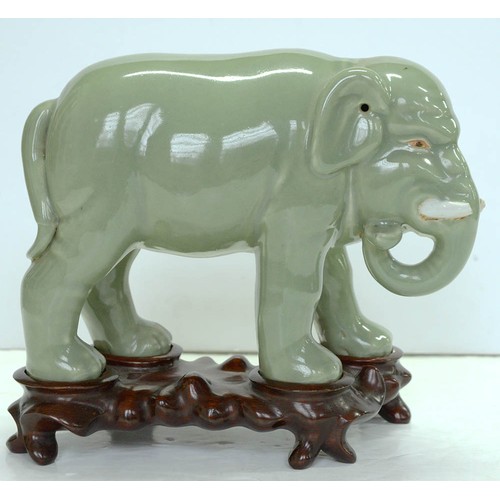 200 - A Chinese celadon model of an elephant,  20th c, 18cm h, wood stand (2)The collection of C. W. Brigg... 