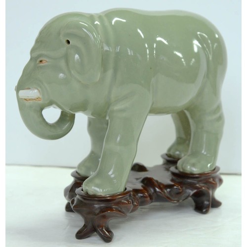 200 - A Chinese celadon model of an elephant,  20th c, 18cm h, wood stand (2)The collection of C. W. Brigg... 