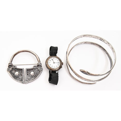 86 - A silver  Tara brooch,  59mm diam, maker's mark rubbed, Chester 1947, a silver wristlet watch and a ... 