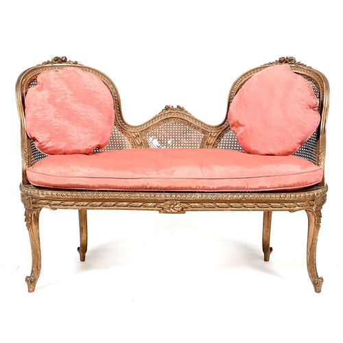 968 - A French giltwood and caned settee, c1900, in Louis XV style, of twin chair back design, the moulded... 