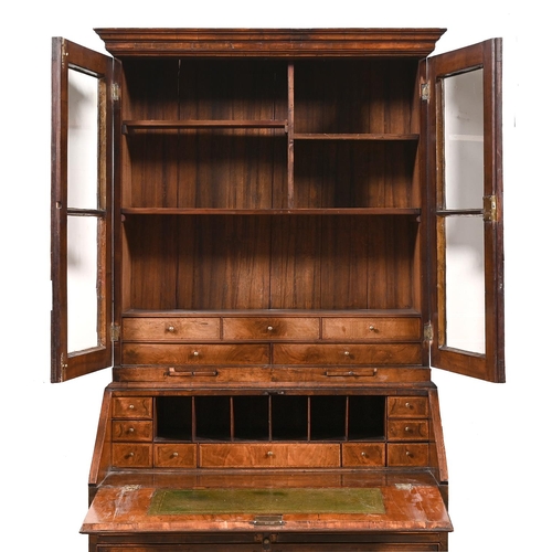 1022 - A walnut bureau-cabinet, with ogee moulded cornice and glazed doors above candle slides, the flap in... 