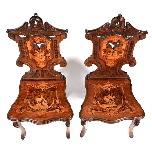 1035 - A pair of Swiss carved, inlaid and etched walnut musical hall chairs, c1900, crested by an eagle, th... 