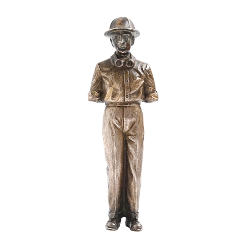 328 - A silvered bronze statuette of a man, early 20th c, in helmet and goggles, 13.5cm h