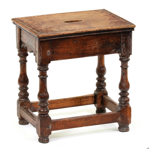 1019 - An oak joined stool, 20th c, the top with hand hole, on baluster legs united by stretchers, 44cm h; ... 