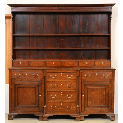 1024 - A George III oak dresser, North Wales, the three shelf boarded rack with stepped cornice and shaped ... 