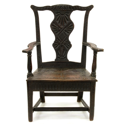 1241 - A George III oak elbow chair, profusely carved and stained in the late 19th c