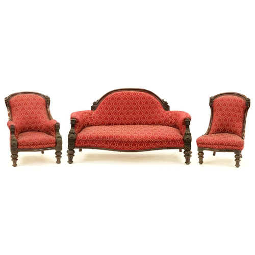 1242 - A Victorian carved mahogany suite, the settee, arm and nursing chairs with arched back rail and leaf... 