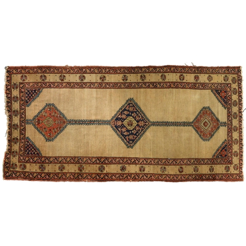 1252 - A Persian medallion rug, first-half 20th c, ochre ground with geometric motifs and stylized foliage,... 