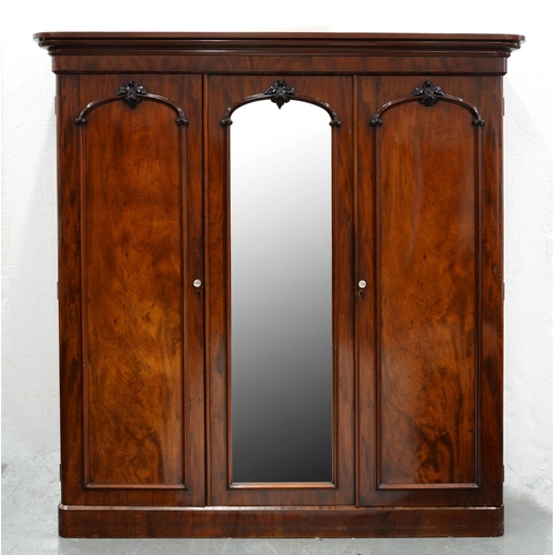 1268 - A Victorian mahogany triple-wardrobe, c. 1860, steppped cornice above moulded architectural doors, c... 