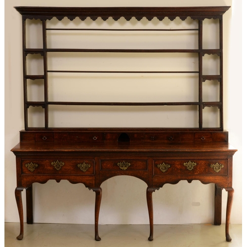 1310 - A George III oak dresser, the low upstand fitted with spice drawers beneath associated rack, the bas... 