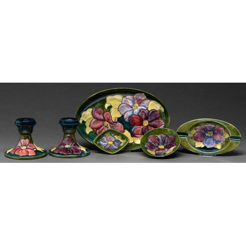 608 - A pair of Moorcroft Clematis candlesticks, three dishes and an ashtray, c1970, candlesticks 85cm h, ... 