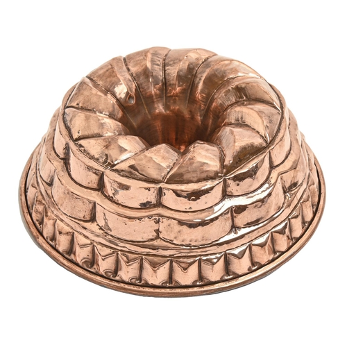 854 - A round copper tiered culinary mould, early 20th c, with rolled rim, 24.5cm diam