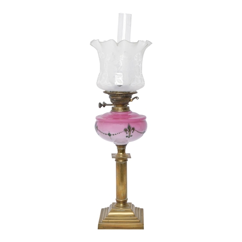 211 - A brass columnar oil lamp, c1900, the shaded pink glass font decorated in green with fleur de lis, b... 