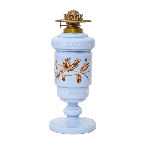 215 - An enamelled lavender blue glass oil lamp and fount, c1890, decorated in sepia and white with a bird... 