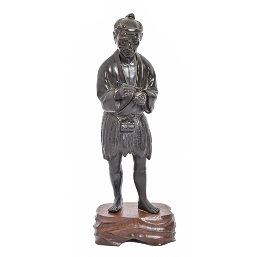 230 - A Japanese bronze statuette of a man, Tokyo School, Meiji period, holding a pipe, black patina, 32cm... 