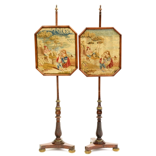 504 - A pair of early Victorian brass mounted rosewood pole-screens, with octagonal framed Berlin woolwork... 