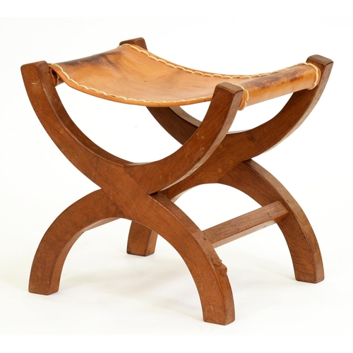 518 - A 'Mouseman' oak X-frame stool, 1970's, lightly fumed, with tan leather sling seat, 52.5cm h, carved... 