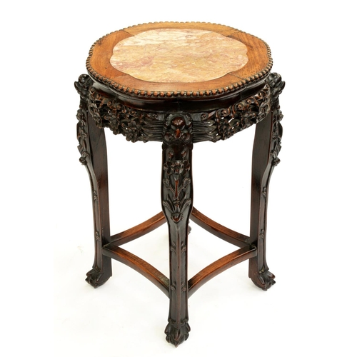 519 - A Chinese carved hardwood stand, c1900, with pink stone inset top and pierced apron, on four legs un... 