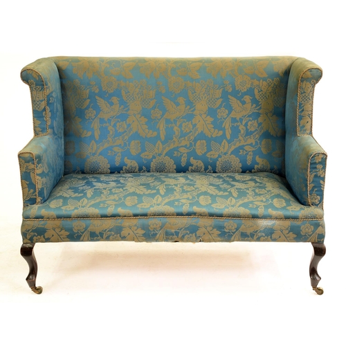 550 - A wingback settee, c1920, on stained wood cabriole forelegs, brass castors, 133cm l