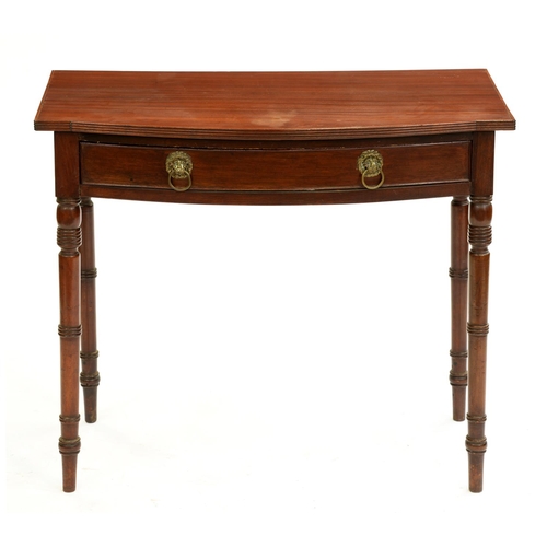 558 - A George IV bow fronted mahogany side table, the finely figured top with drawer, on ring turned legs... 