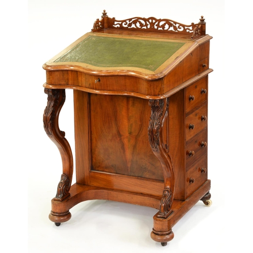 587 - A Victorian walnut davenport, with fretwork gallery and serpentine front, sycamore veneered interior... 