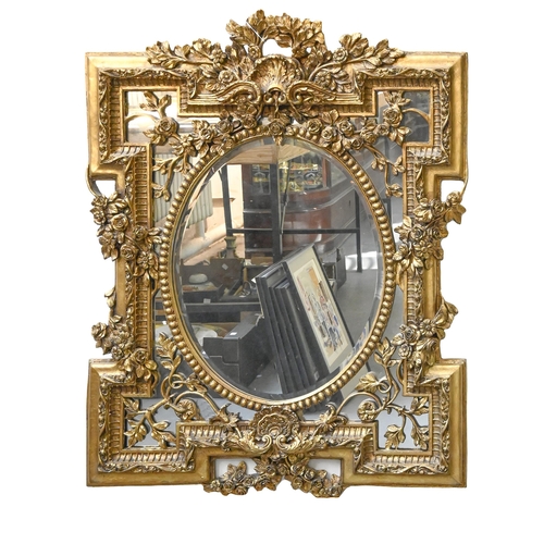 1158 - A giltwood and composition mirror, the frame decorated with flowers and foliage, the central oval mi... 