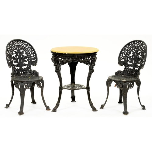 1175 - A black painted wrought iron pub table, 76cm h and a pair of associated chairs