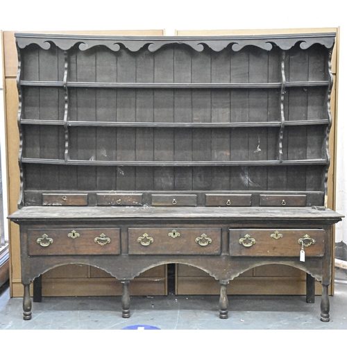 1180 - A George III oak dresser and rack, the base with boarded top, fitted with three drawers, on turned l... 