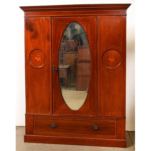 1487 - An Edwardian marquetry inlaid mahogany wardrobe, the door inset with an oval mirror with bevelled pl... 