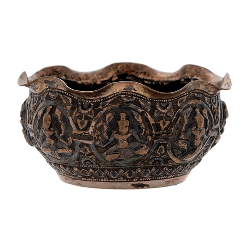 321 - A Burmese silver repousse bowl, early 20th c, decorated with eight deities beneath wavy rim, 11cm di... 