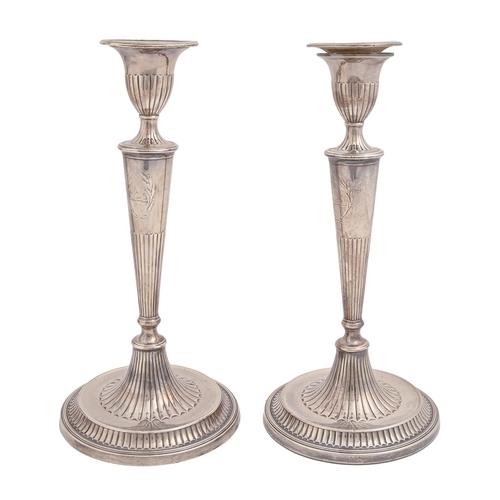 366 - A pair of George III neo classical silver candlesticks, crested within chased cartouche, nozzles, 29... 