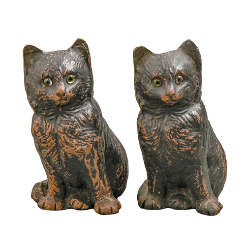 555 - A pair of Bretby black painted earthenware models of glass-eyed cats, c1900, 18cm h, impressed mark... 