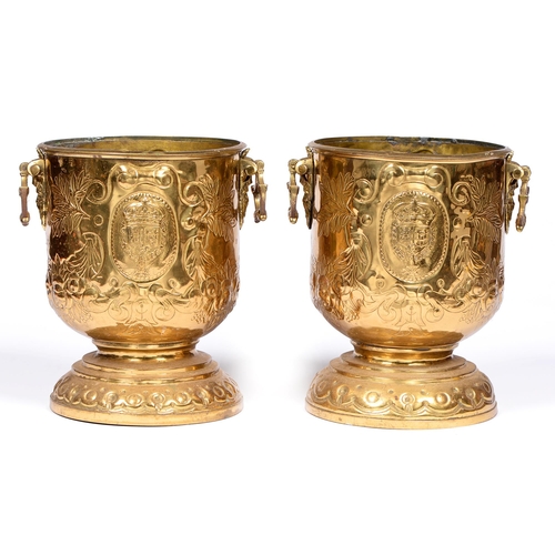 815 - A pair of Northern European embossed brass wine coolers, early 20th c, with pseudo armorials and mas... 