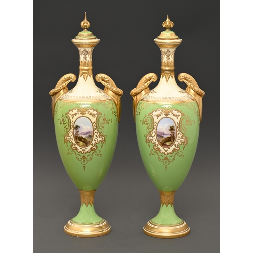 850 - A pair of Coalport vases and covers, c1910, of shield shape, painted with highland landscapes in rai... 