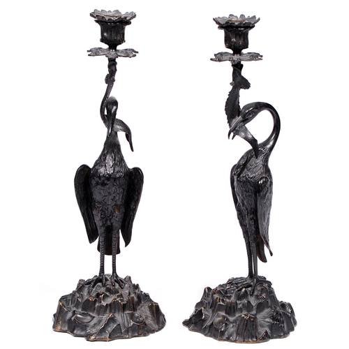 1064 - A pair of bronze 'stork' candlesticks, attributed to Thomas Abbott, 19th c, the fish in the bird's b... 