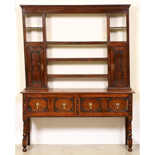 1198 - An oak dresser, early 20th c, the rack with two spice cupboards with geometrically panelled doors, t... 