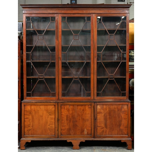 1196 - A Victorian mahogany bookcase, fitted with shelves enclosed by three glazed doors, the lower part wi... 