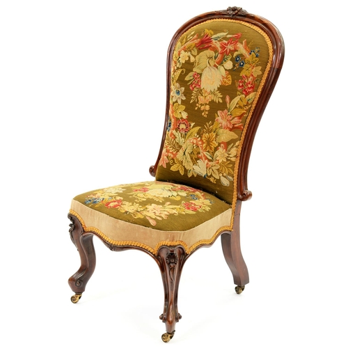 1260 - A Victorian rosewood nursing chair, the padded back in moulded frame crested by a carved flower, on ... 